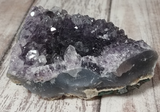 Natural Purple Gemstone Mineral on wood grain background