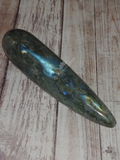 Natural Labradorite Wand on Wood grain background