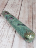 Ruby Fushite wand on wood grain background