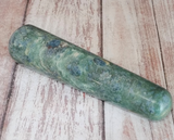 Ruby Fushite wand on wood grain background