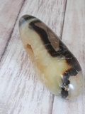 Natural Yellow Gray and Brown Gemstone Wand on Wood grain background