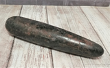Rhodonite wand on wood grain background