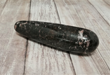 Rhodonite massage wand on wood grain background