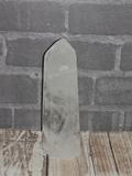 Carved Gemstone Obelisk on brick and Wood Grain background