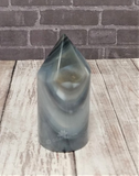 Brazilian Agate carved tower on wood grain and brick background