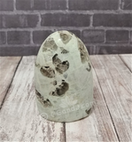 Garnierite cut base free form tower with wood grain and brick background Gypsy Gems & Jewelry GGandJ.com Naturally Unique