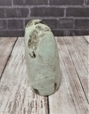 Green gemstone mineral Garnierite on Wood grain background Gypsy Gems & Jewelry