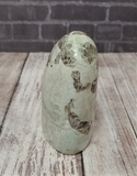 Garnierite cut base free form tower with wood grain and brick background Gypsy Gems & Jewelry GGandJ.com Naturally Unique