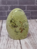 Opal cut base free form from Madagascar on brick and wood grain background