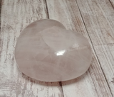 Hand carved rose quartz gemstone heart from Madagascar on Wood grain background for sale