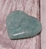 Amazonite heart from Madagascar on wood grain background