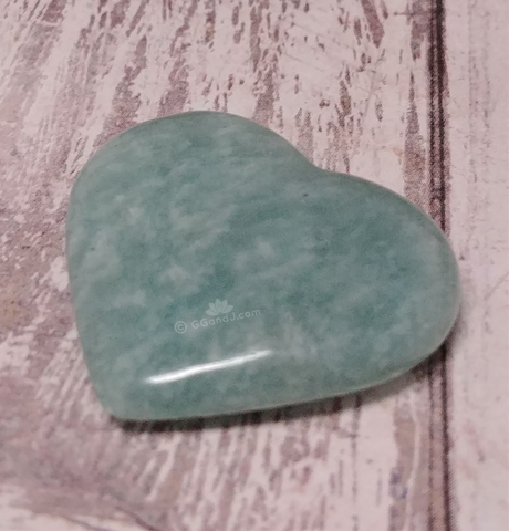 Amazonite heart from Madagascar on wood grain background