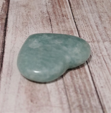 Amazonite heart from Madagascar on wood grain background