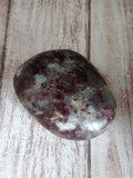 Hand carved gemstone gallet on wood grain background Rhodonite Gypsy Gems & Jewelry Naturally Unique GGandJ.com