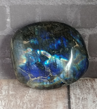 Iridescent gemstone on wood grain background Labradorite from Madagascar GGandJ.com