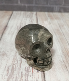Hand carved gemstone skull from Brazil on Wood grain background 