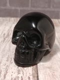 Carved Gemstone Skull GGandJ.com with brick and wood grain background
