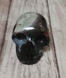 Hand carved gemstone skull from Brazil on Wood grain background