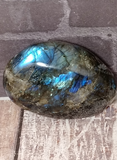 Iridescent gemstone on wood grain background Labradorite from Madagascar GGandJ.com