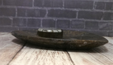 Side view of ammonite heart plate on wood grain background