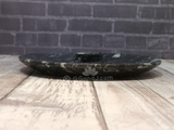 Side view of ammonite small oval plate on wood grain background
