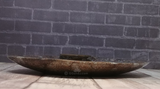 Side view of ammonite oblong plate on wood grain background