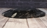 Side view of ammonite oval plate on wood grain background