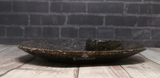Side view of ammonite large round plate on wood grain background