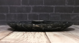 Side view of ammonite oval plate on wood grain background