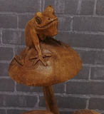 Close up of wood frog on mushroom statue