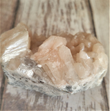 Spiky peach gemstone on wood grain background GGandJ.com
