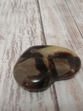 Yellow and gray gemstone on wood grain
