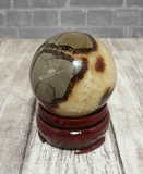 Gemstone Sphere Yellow Brown and Gray on Wood stand brick and woodgrain background GGandJ.com