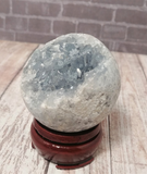 Celestite Gemstone from Madagascar Sphere on wood grain