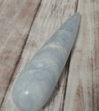 Celestite Gemstone from Madagascar wand on wood grain