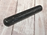 Natural black gemstone wand on wood grain background