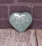 Hand carved gemstone heart from Madagascar on Wood grain background 
