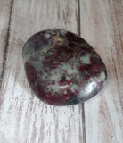 Natural purple and white gemstone gallet on wood grain background