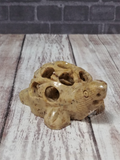 Hand carved soapstone turtle on brick and wood grain background