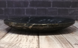Side view of ammonite oval plate on wood grain background