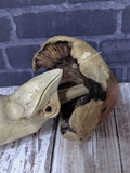 Close up of wood frog under mushroom umbrella statue