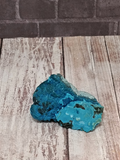 blue and aqua rock on wood grain and brick background