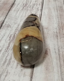 Yellow and gray gemstone on wood grain